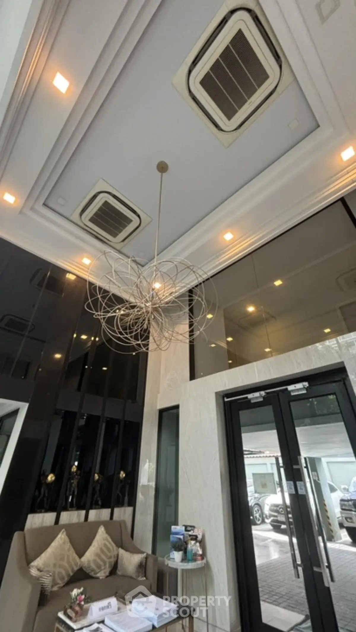 Elegant building entrance with modern chandelier and glass doors