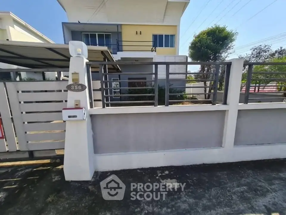 Modern two-story house with gated entrance and spacious driveway
