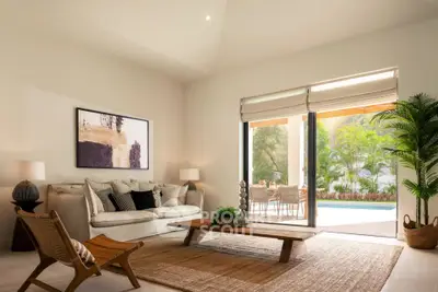 Elegant living room with pool view, stylish decor, and natural light.