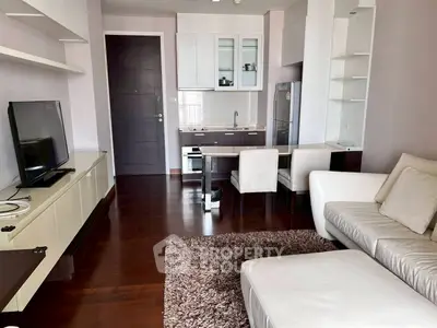 Modern living room with sleek furniture and open kitchen layout in a stylish apartment.