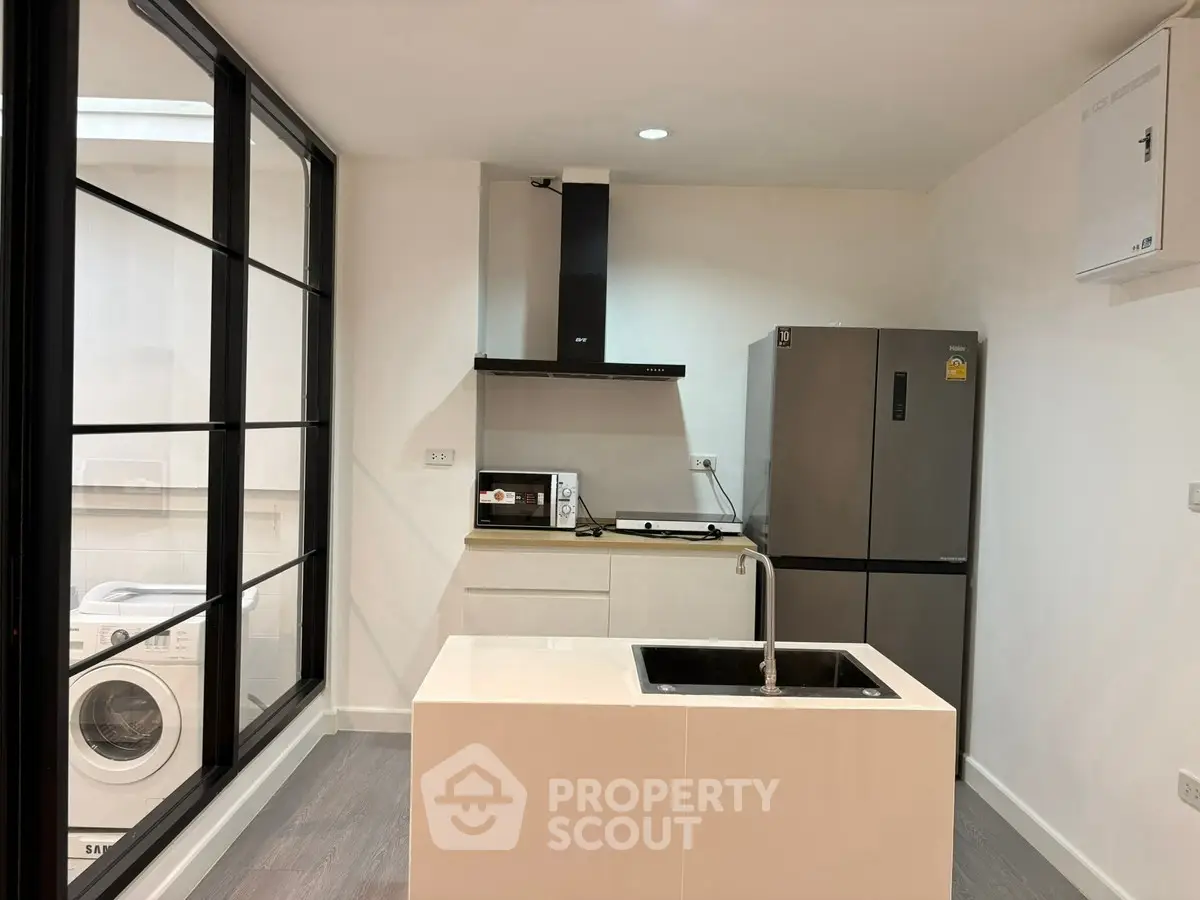 Modern kitchen with sleek appliances and large window for natural light