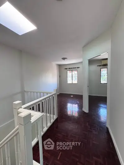Spacious hallway with wooden flooring and natural light, perfect for a cozy home ambiance.