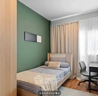 Cozy bedroom with single bed, desk, and green accent wall