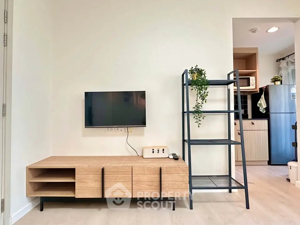 Modern living room with sleek TV stand and open kitchen layout, perfect for contemporary living.