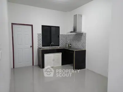 Modern minimalist kitchen with sleek black and white design, featuring a compact layout and stylish backsplash.