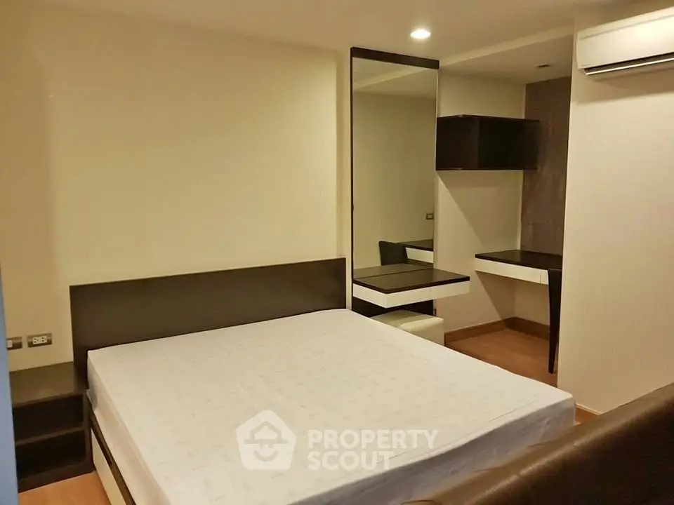 Modern bedroom with sleek furniture and built-in air conditioning unit.