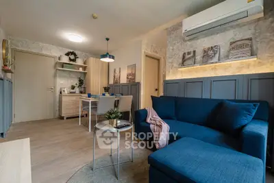 Modern living room with blue sofa, dining area, and air conditioning in stylish apartment.