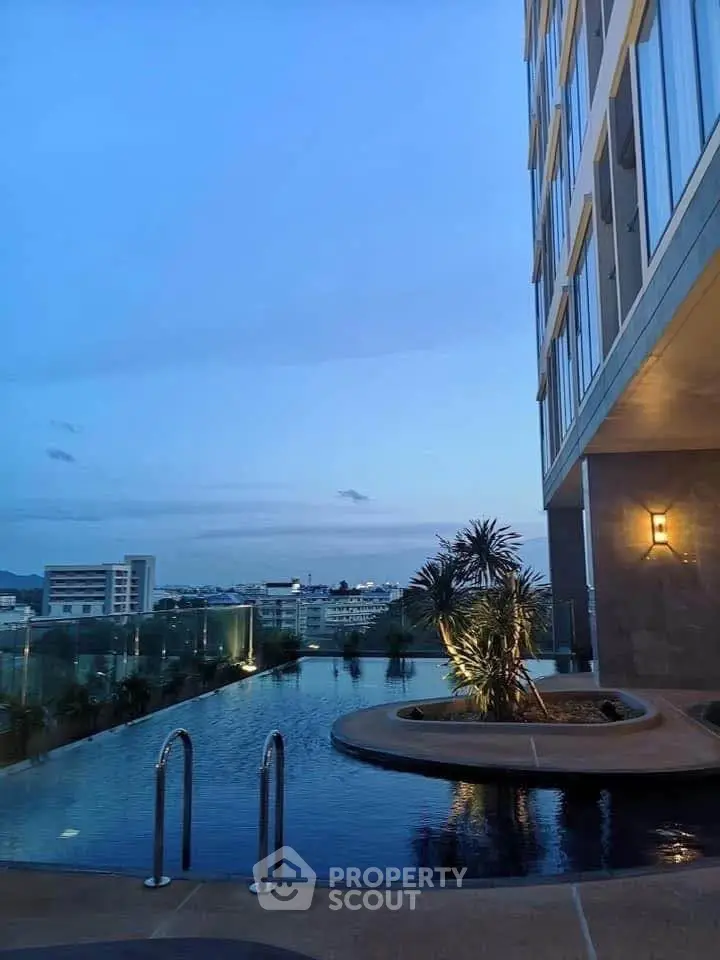 Luxurious rooftop pool with stunning city views at dusk, perfect for relaxation and leisure.