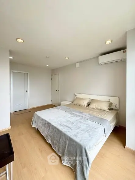 Spacious bedroom with modern decor and natural light