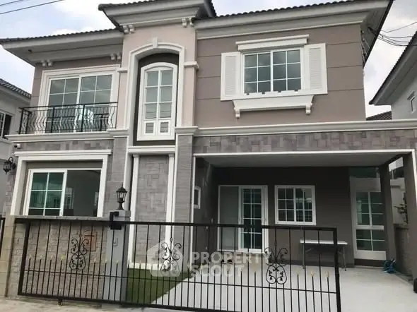 Elegant two-story house with modern facade and spacious balcony in a serene neighborhood.