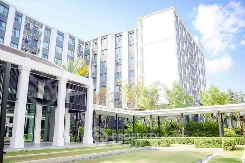 Modern apartment building with lush landscaping and clear blue sky
