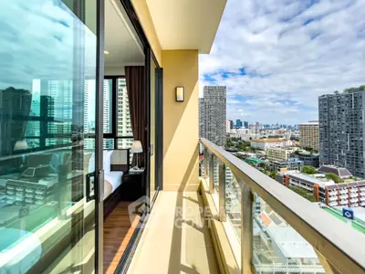 Stunning city view from a modern high-rise balcony with glass railing.