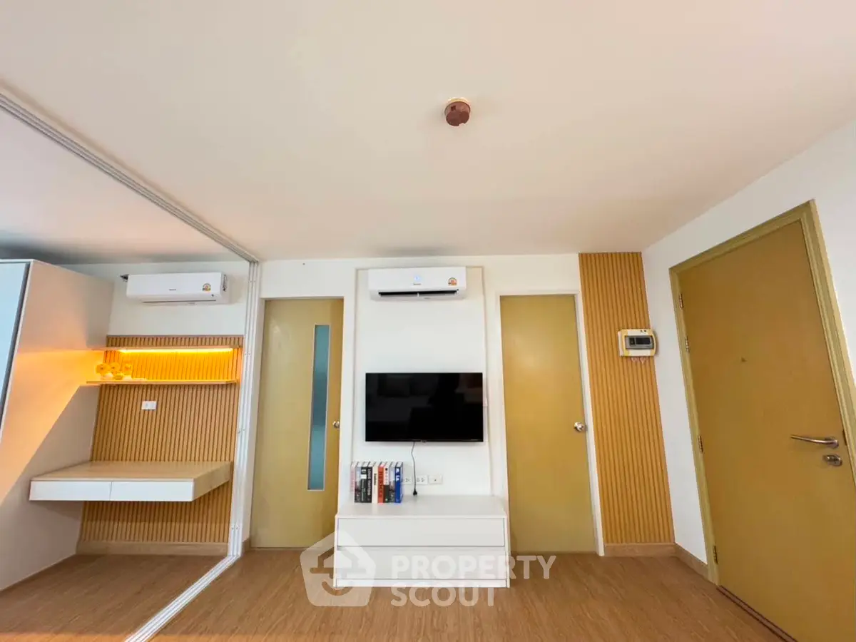 Modern living room with sleek design, featuring built-in storage and air conditioning.