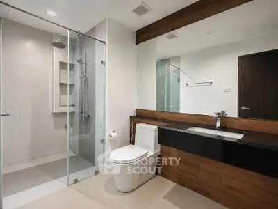 Modern bathroom with glass shower and sleek wooden vanity