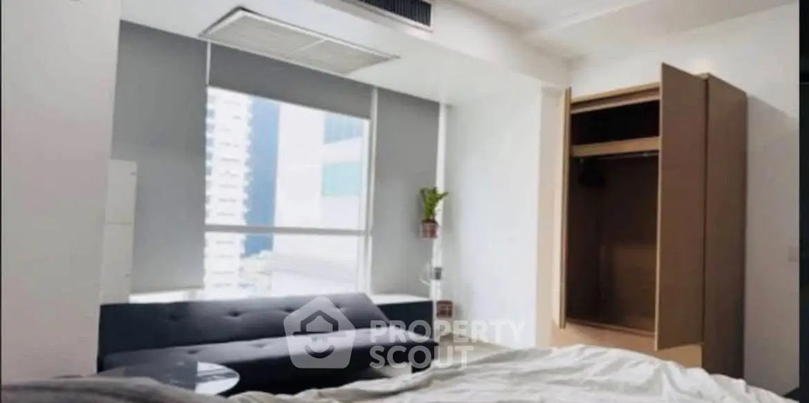 Modern bedroom with open closet and city view, featuring sleek design and natural light.