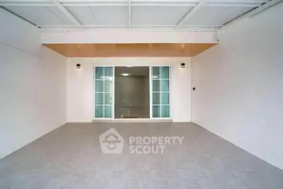 Spacious covered patio with sliding glass doors and modern lighting, perfect for outdoor relaxation.