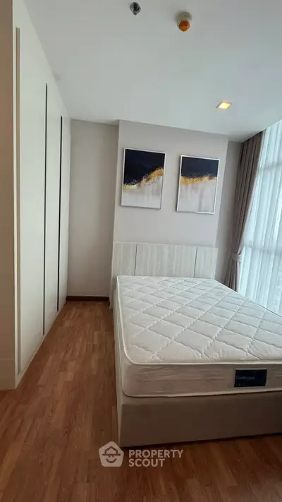 Modern bedroom with stylish decor and large window for natural light