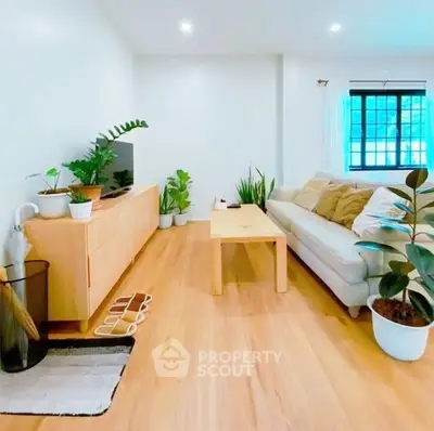 Bright and airy living room with modern decor and wooden flooring, perfect for relaxation.