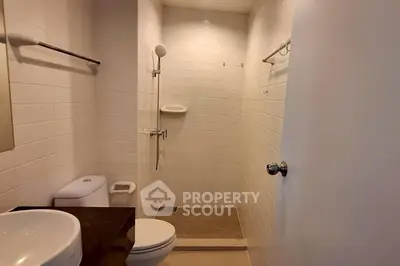 Modern bathroom with sleek fixtures and walk-in shower in a contemporary apartment.