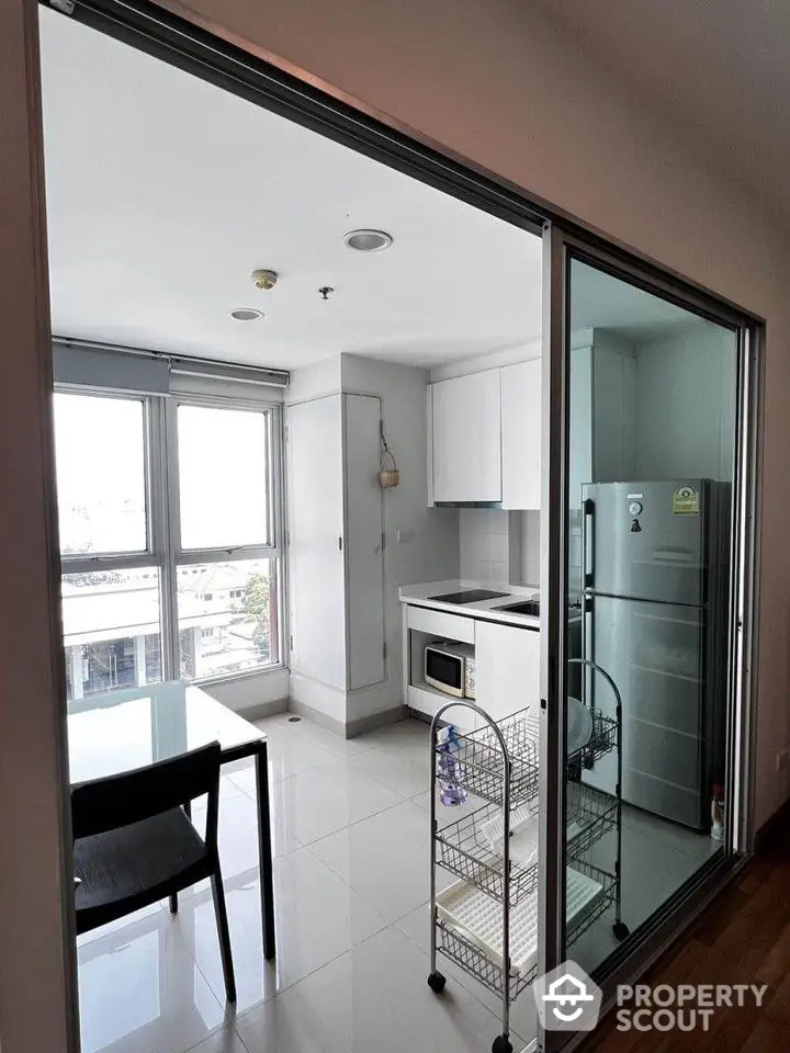 Modern kitchen with sleek appliances and dining area in bright apartment