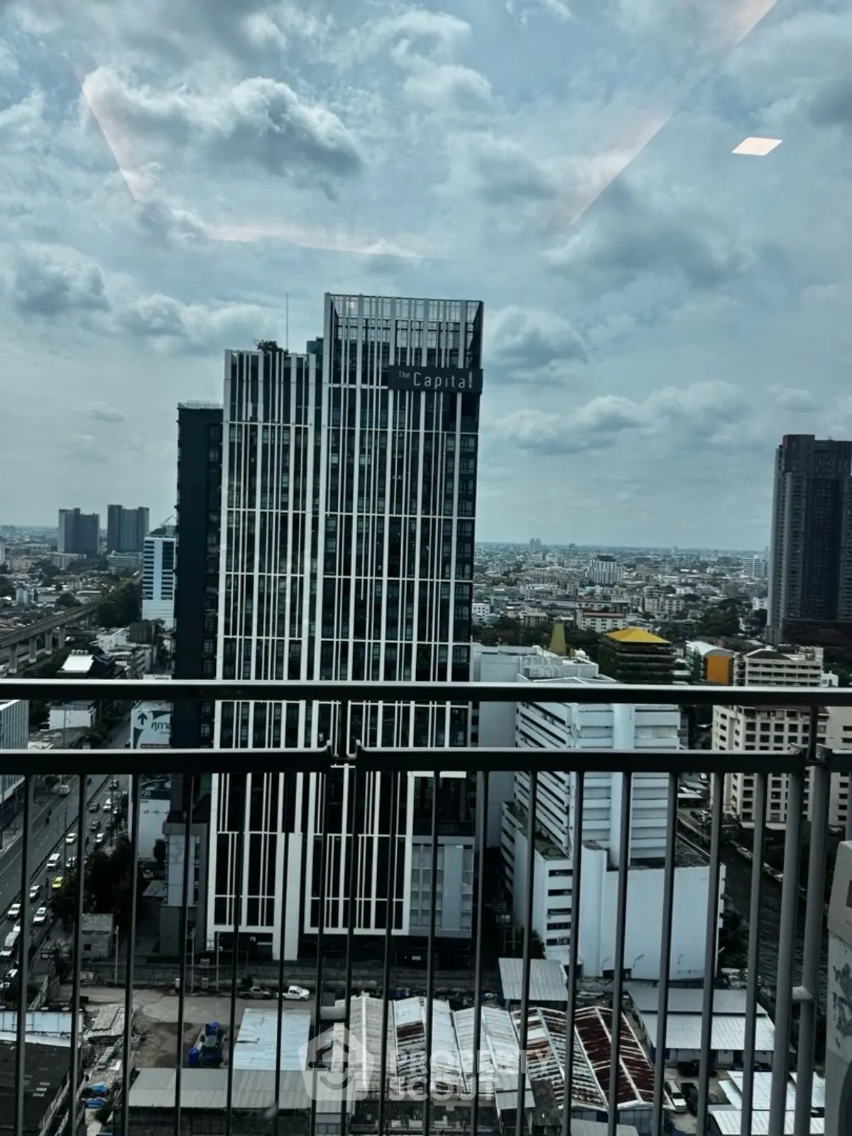 Stunning cityscape view from a high-rise balcony overlooking modern urban architecture.