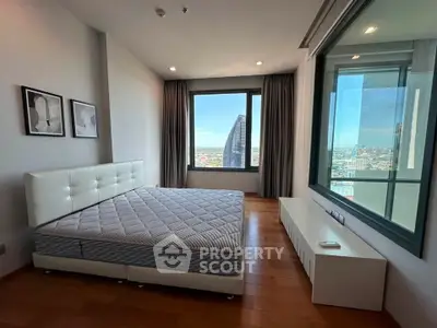 Spacious bedroom with city view and modern decor in high-rise apartment