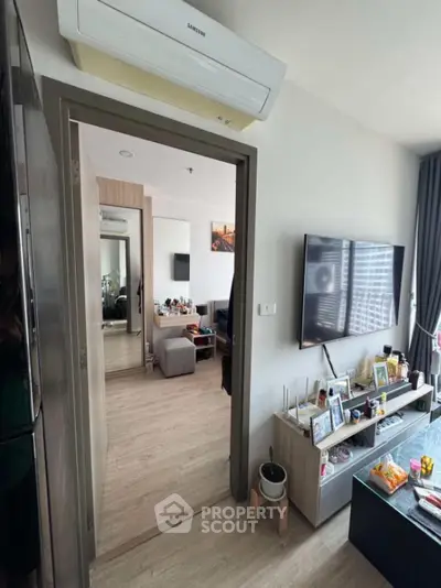 Modern living room with sleek decor and wall-mounted TV in cozy apartment