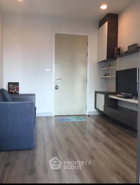 Modern living room with sleek wooden flooring and stylish shelving unit.
