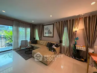 Spacious living room with modern decor and large windows leading to a balcony.