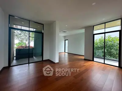 Spacious modern living room with large windows and wooden flooring