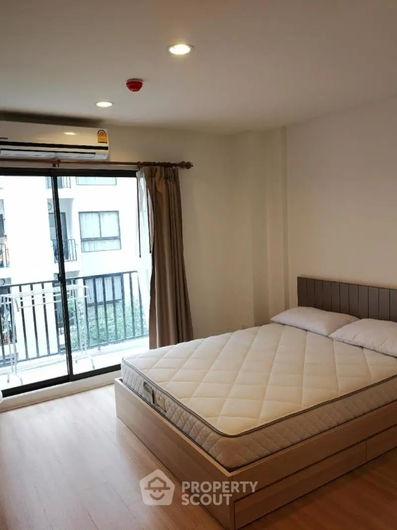 Modern bedroom with balcony access and natural light in urban apartment