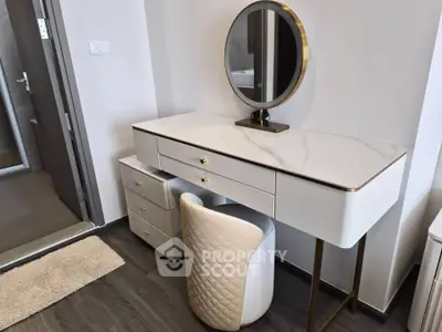 Elegant modern vanity setup in a stylish bedroom with marble top and round mirror.