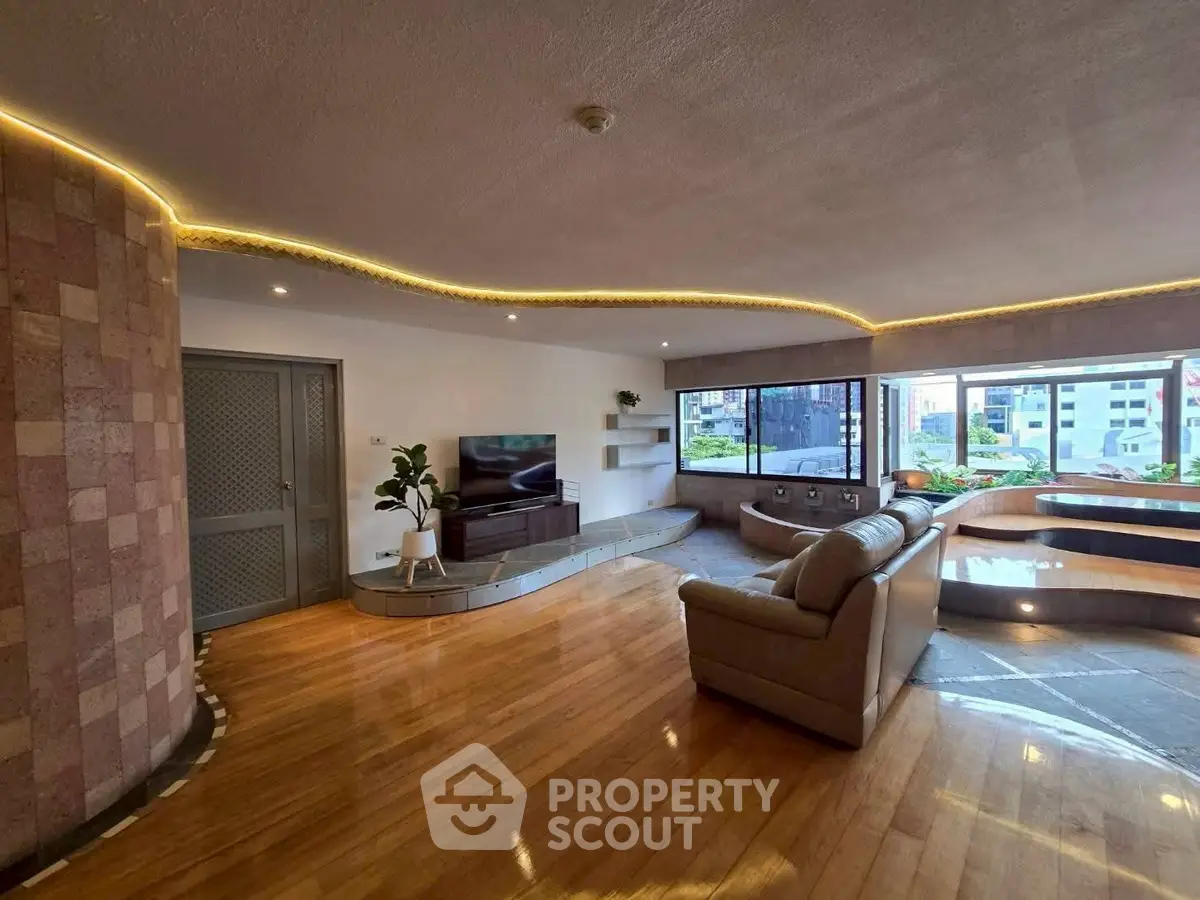 Spacious living room with modern design and large windows offering city views.