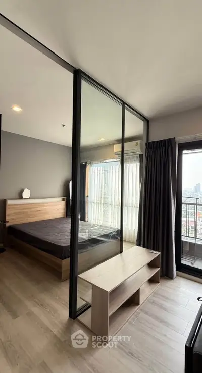 Modern bedroom with glass partition and city view balcony