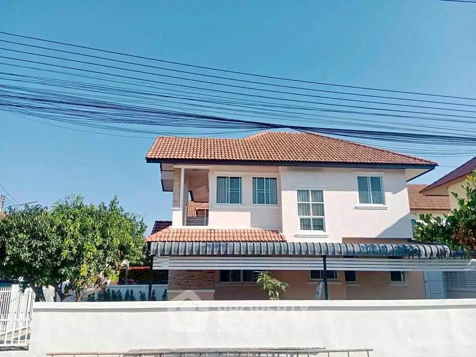 Charming two-story house with red-tiled roof and spacious balcony in a serene neighborhood.