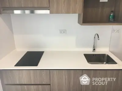 Modern kitchen with sleek cabinetry and integrated sink and stovetop.