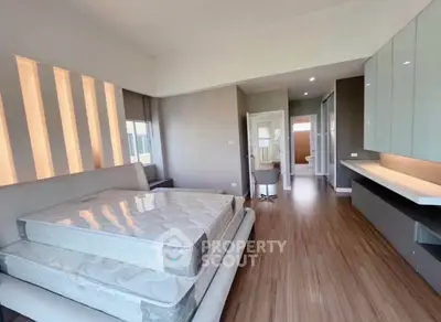 Spacious bedroom with modern design and ample natural light, featuring sleek flooring and stylish furnishings.