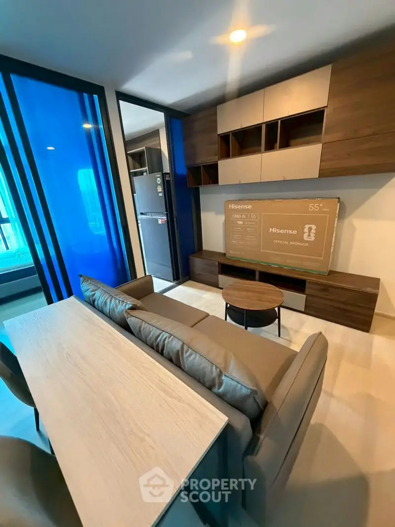 Modern living room with sleek furniture and large TV, featuring a stylish open layout and contemporary design.