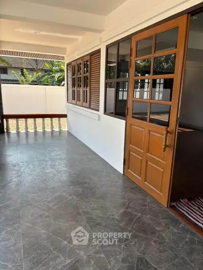 Charming balcony with wooden doors and tiled floor, perfect for relaxation.