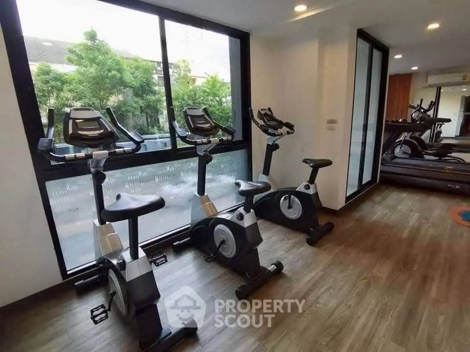 Modern gym with exercise bikes and treadmills in a well-lit fitness area.