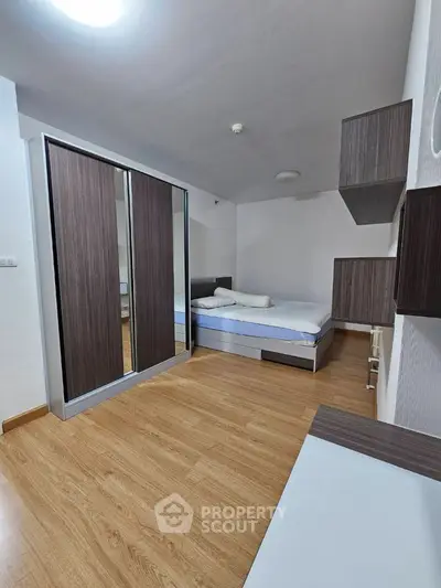 Modern bedroom with sleek wooden flooring and stylish wardrobe