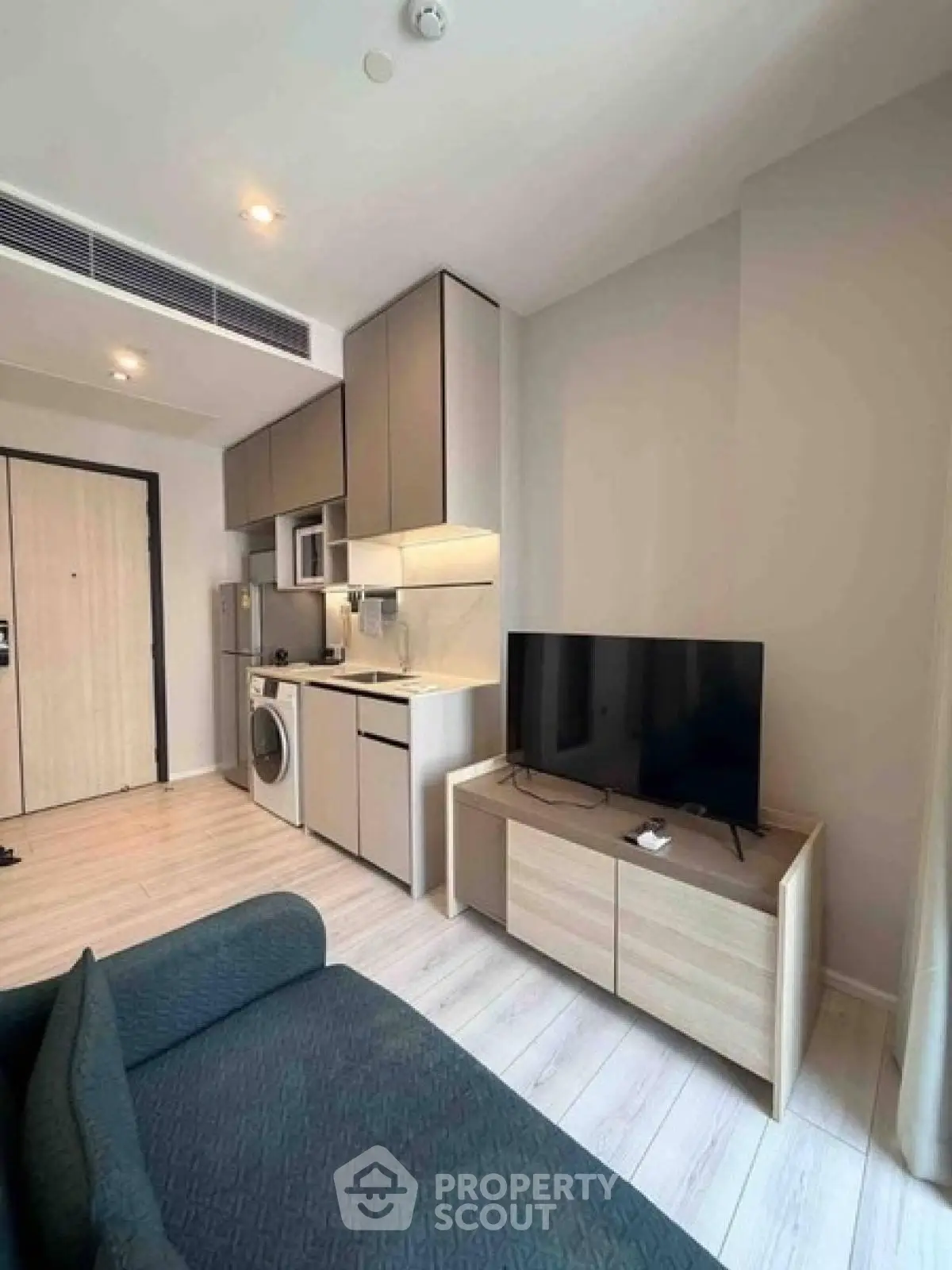 Modern compact living room with integrated kitchen and sleek furniture