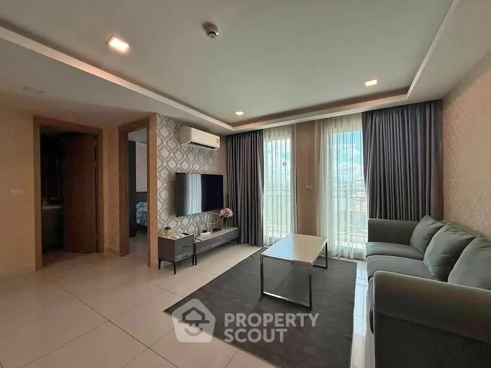 Modern living room with sleek furniture and large windows offering natural light.