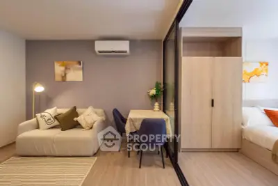 Modern living room with cozy sofa, dining area, and sliding glass door to bedroom.