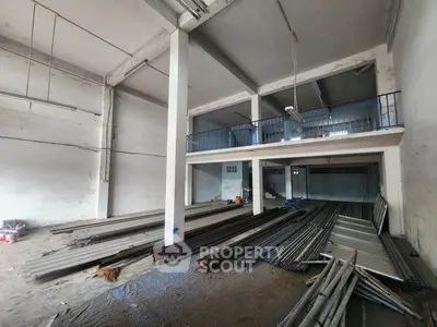 Spacious industrial warehouse with high ceilings and mezzanine level, ideal for storage or manufacturing.