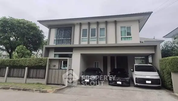 Modern two-story house with three-car garage and landscaped front yard in suburban neighborhood.