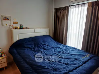 Cozy bedroom with plush bedding and natural light from large window, perfect for relaxation.