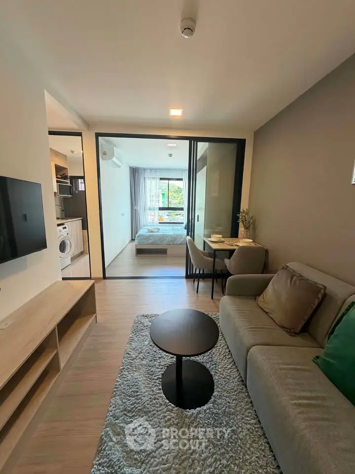 Modern apartment interior with cozy living room and view into stylish bedroom
