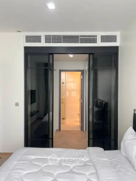 Modern bedroom with sleek glass wardrobe and cozy bedding