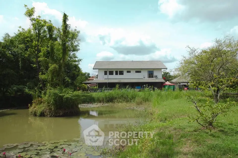 Charming countryside home with serene pond and lush greenery, perfect for nature lovers seeking tranquility.